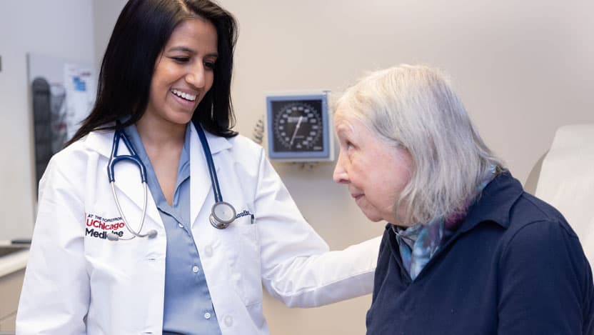 Medical oncologist Noura Choudhury, MD, with a patient in clinic