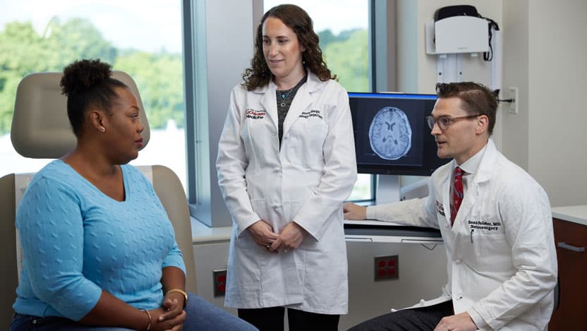 Neurologist Lauren Singer, MD, and neurosurgeon Sean Polster, MD with a patient. Dr. Singer treats neuro-oncology patients and Dr. Polster specializes in minimally invasive surgery of the brain and spine.