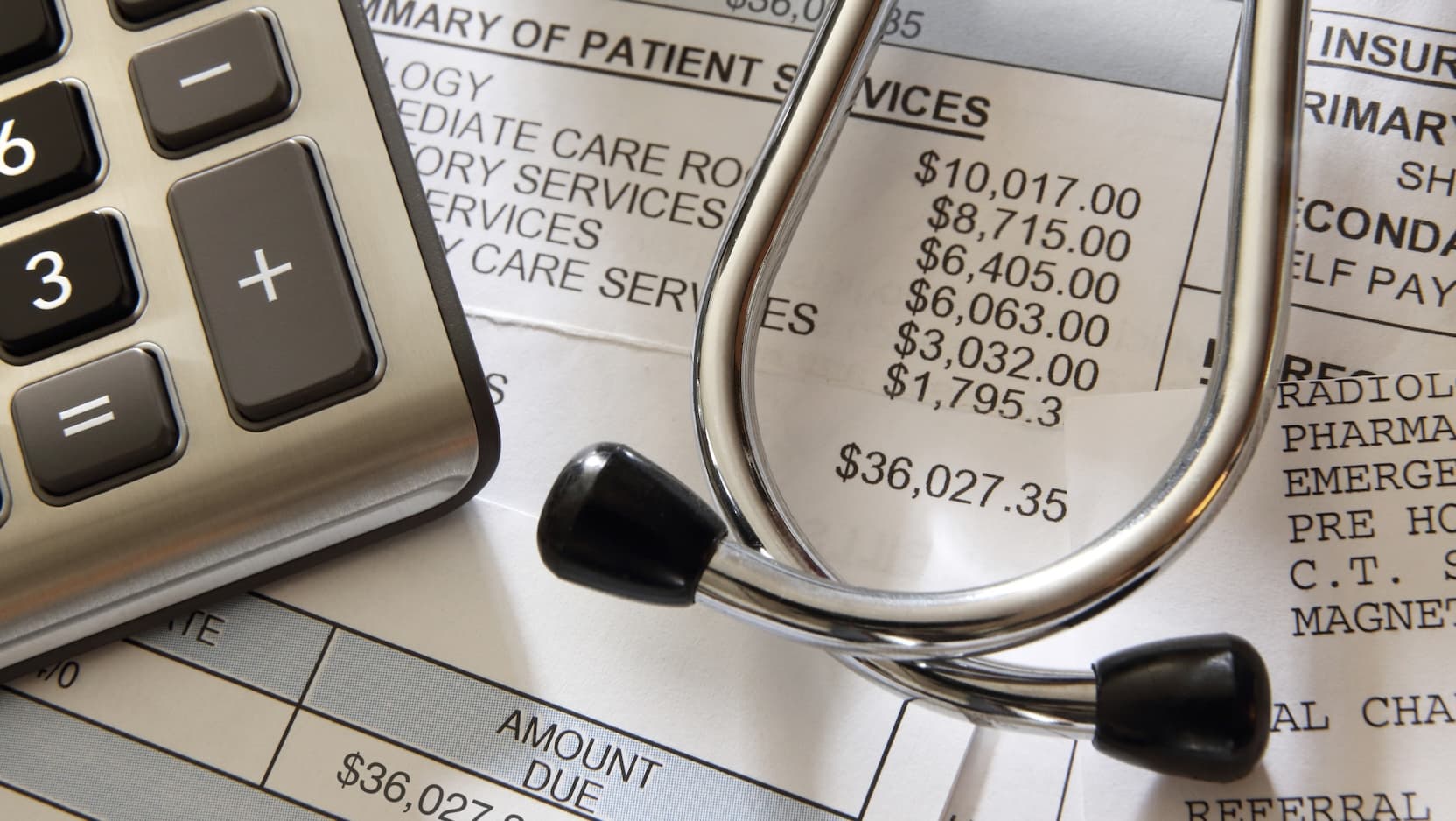 calculator and stethoscope on medical bill