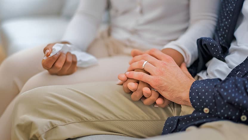 Hand holding tissue of a couple sit on sofa