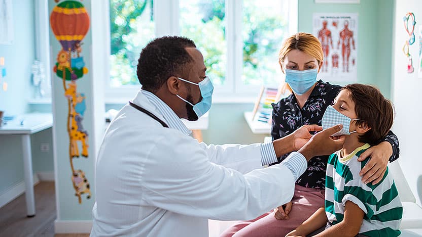 Pediatrician examines child as mom observes