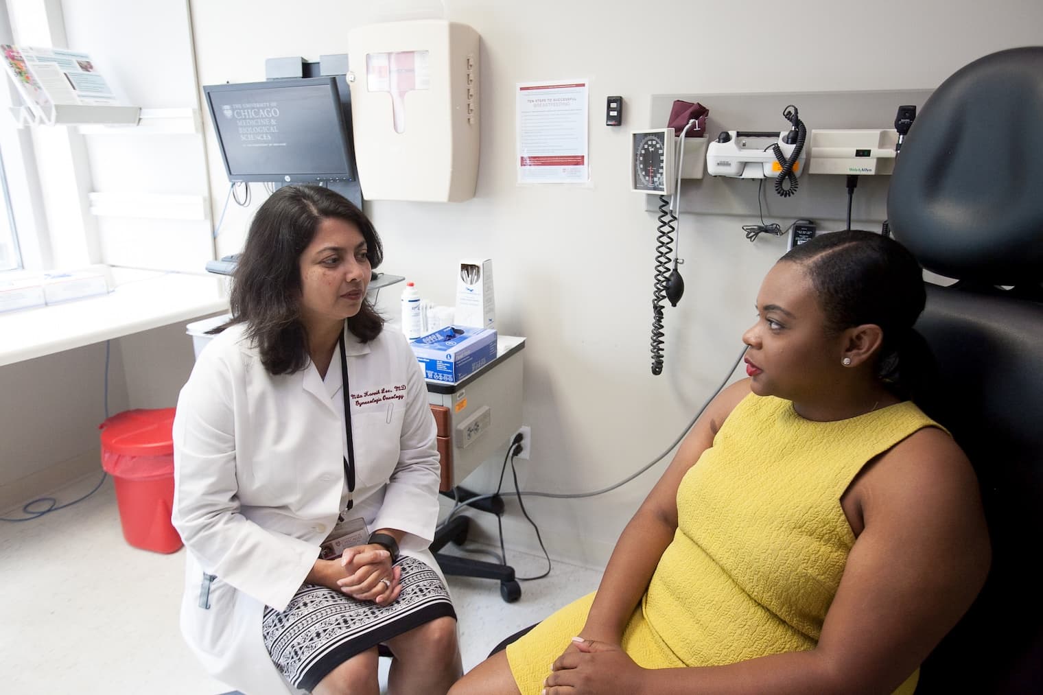 Nita K. Lee, MD, MPH, consults with a patient.