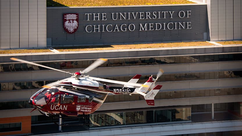 The University of Chicago Medicine Aeromedical Network helicopter flying in front of The University of Chicago Medicine hospital sign