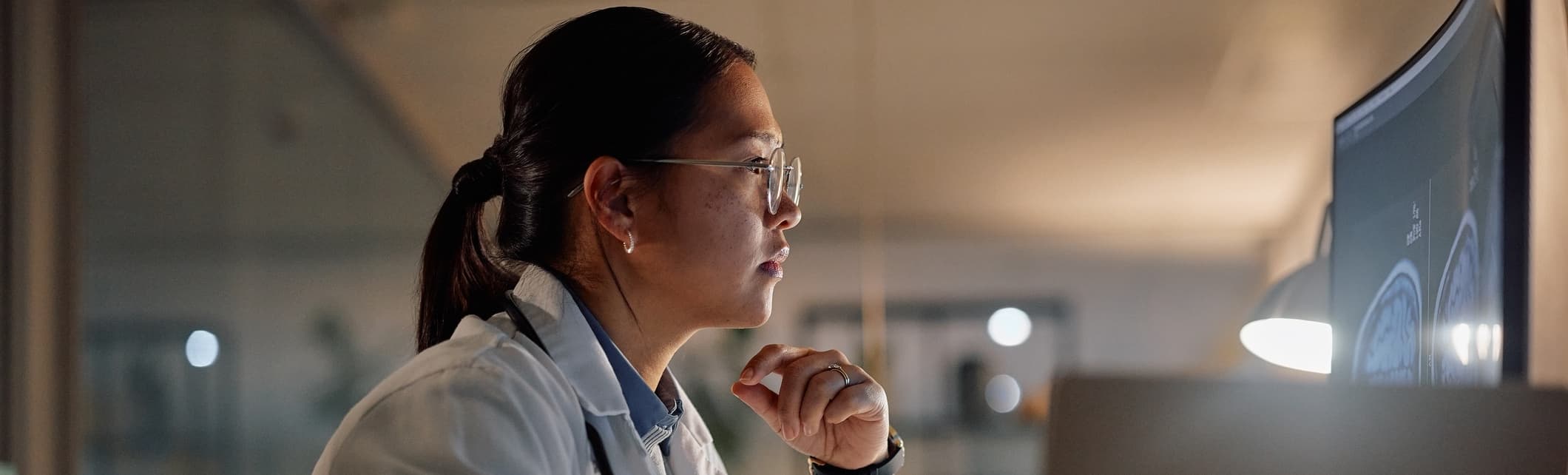 women with glasses looking at brain scan on computer