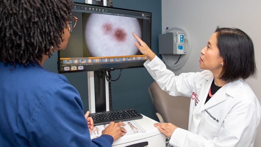 Dermatologist Arlene Ruiz De Luzuriaga, MD, MPH, MBA, viewing a close-up of a mole