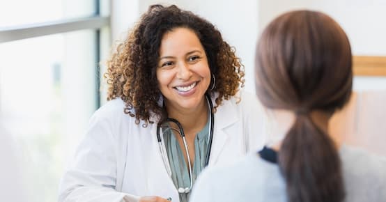 female doctor listening to female patient